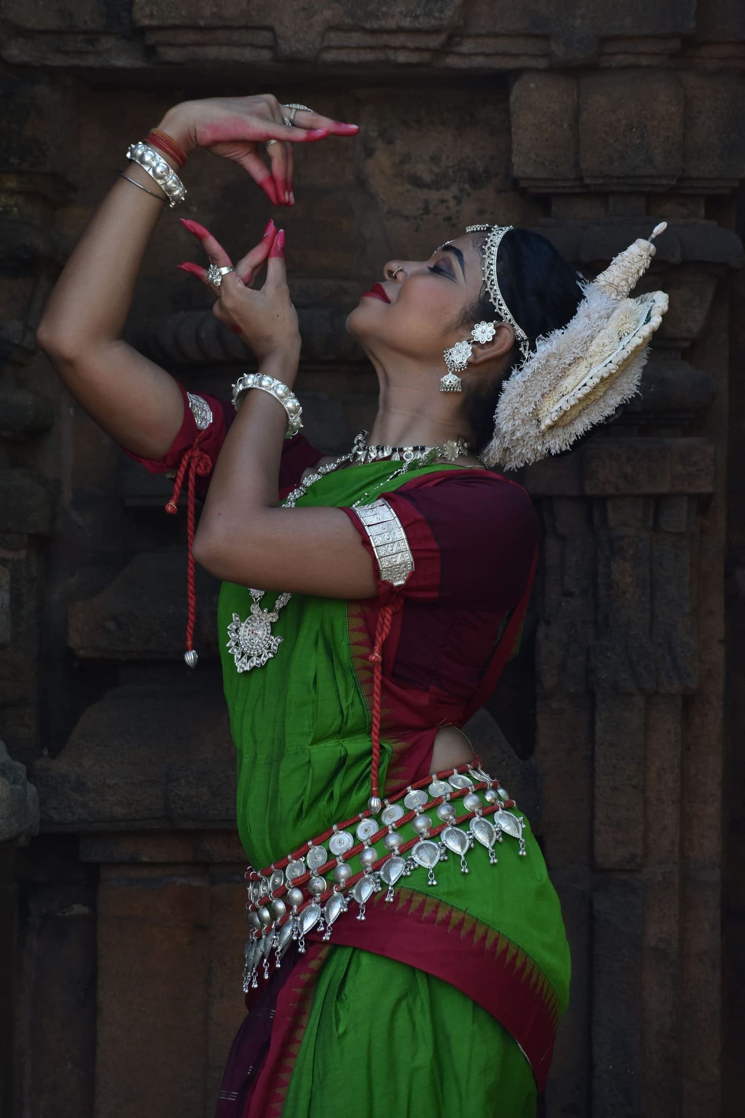 Truptismita Tarini, Founder & Mentor, solo in a dynamic dance stance at a temple niche