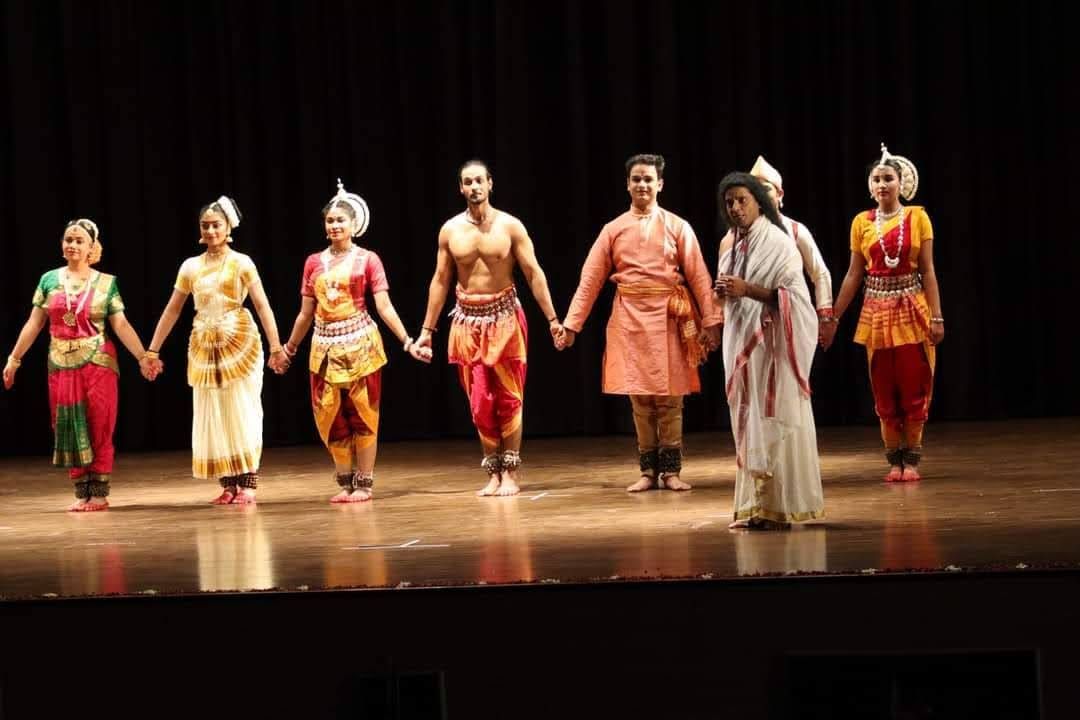 Full cast curtain call at a cultural festival, mixed ensemble