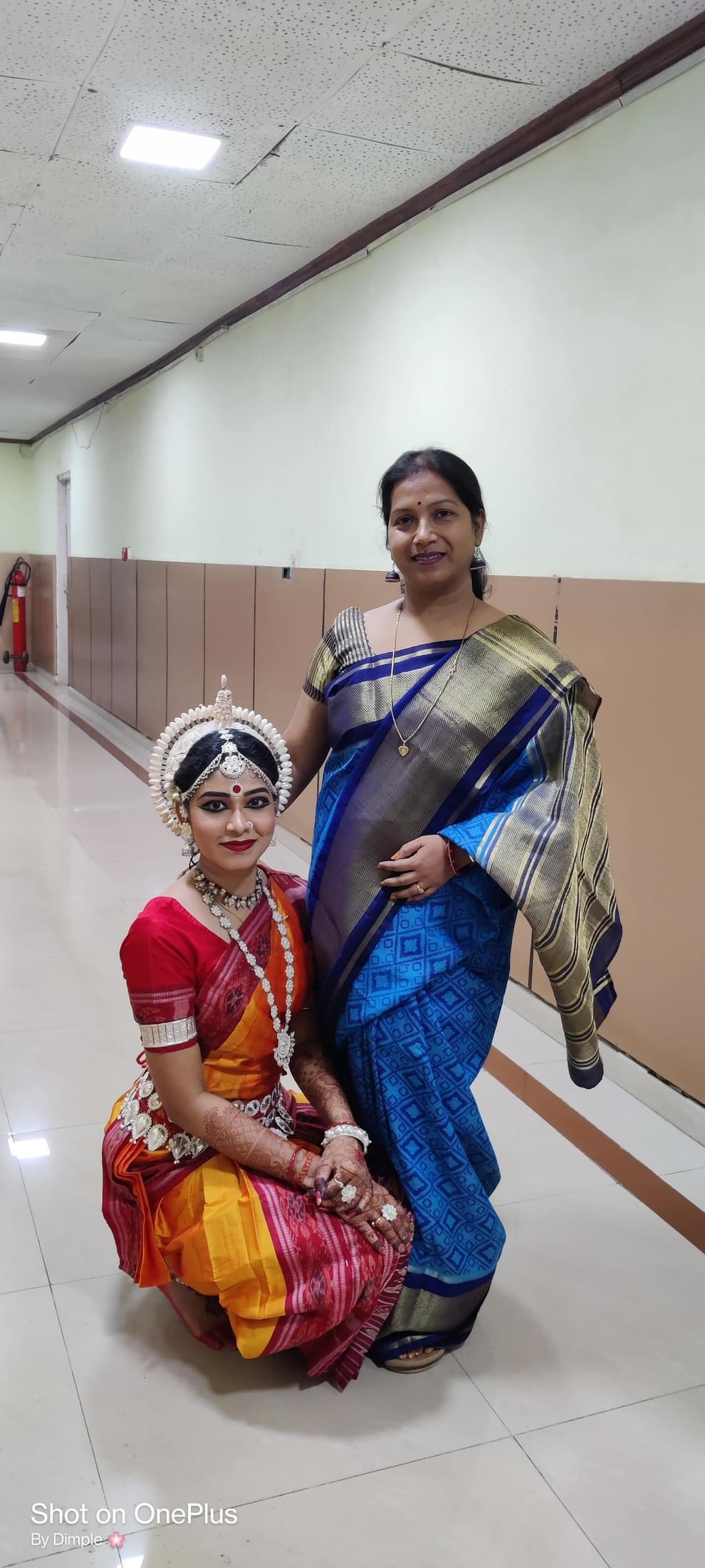 Guru posing with a student backstage, henna-adorned hands