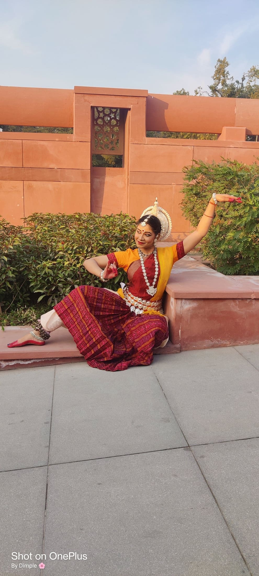 Odissi dancer performing solo with Konark-style architectural backdrop