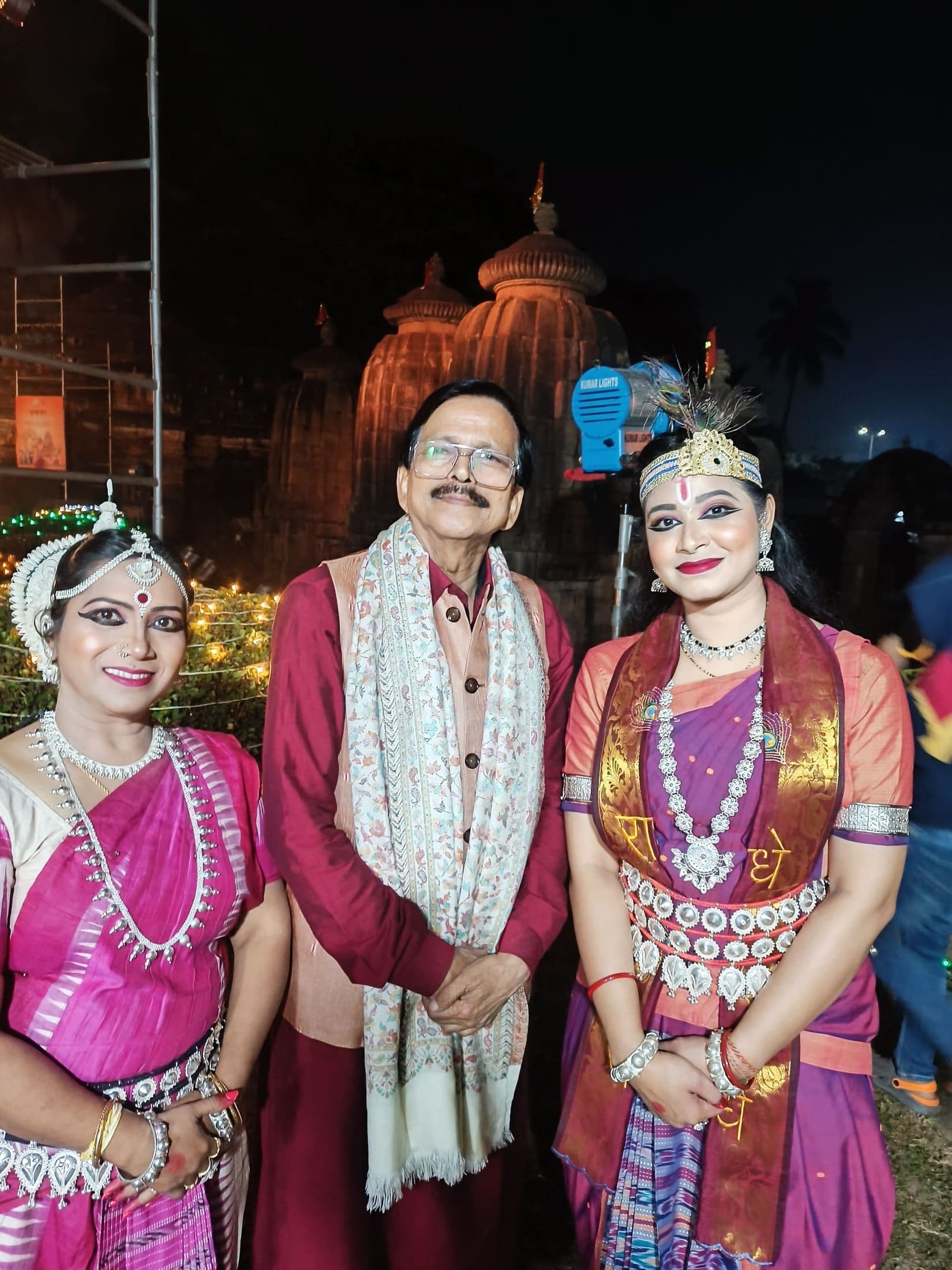 Guru with a senior dignitary and student at the illuminated Konark Sun Temple at night