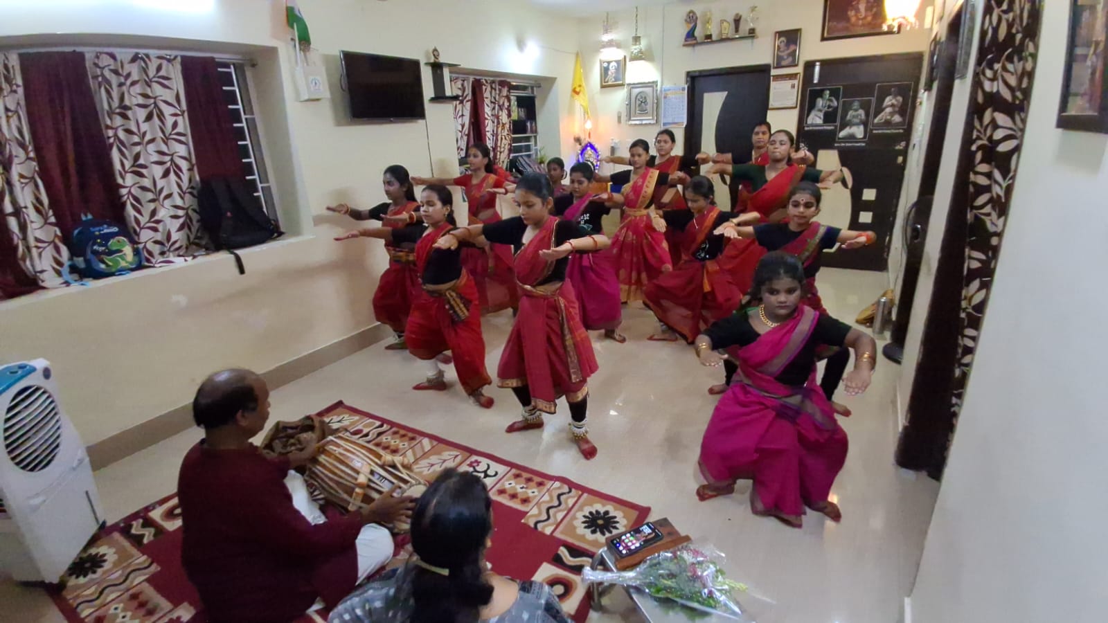 Summer class students seated in a circle on the studio floor with their teacher