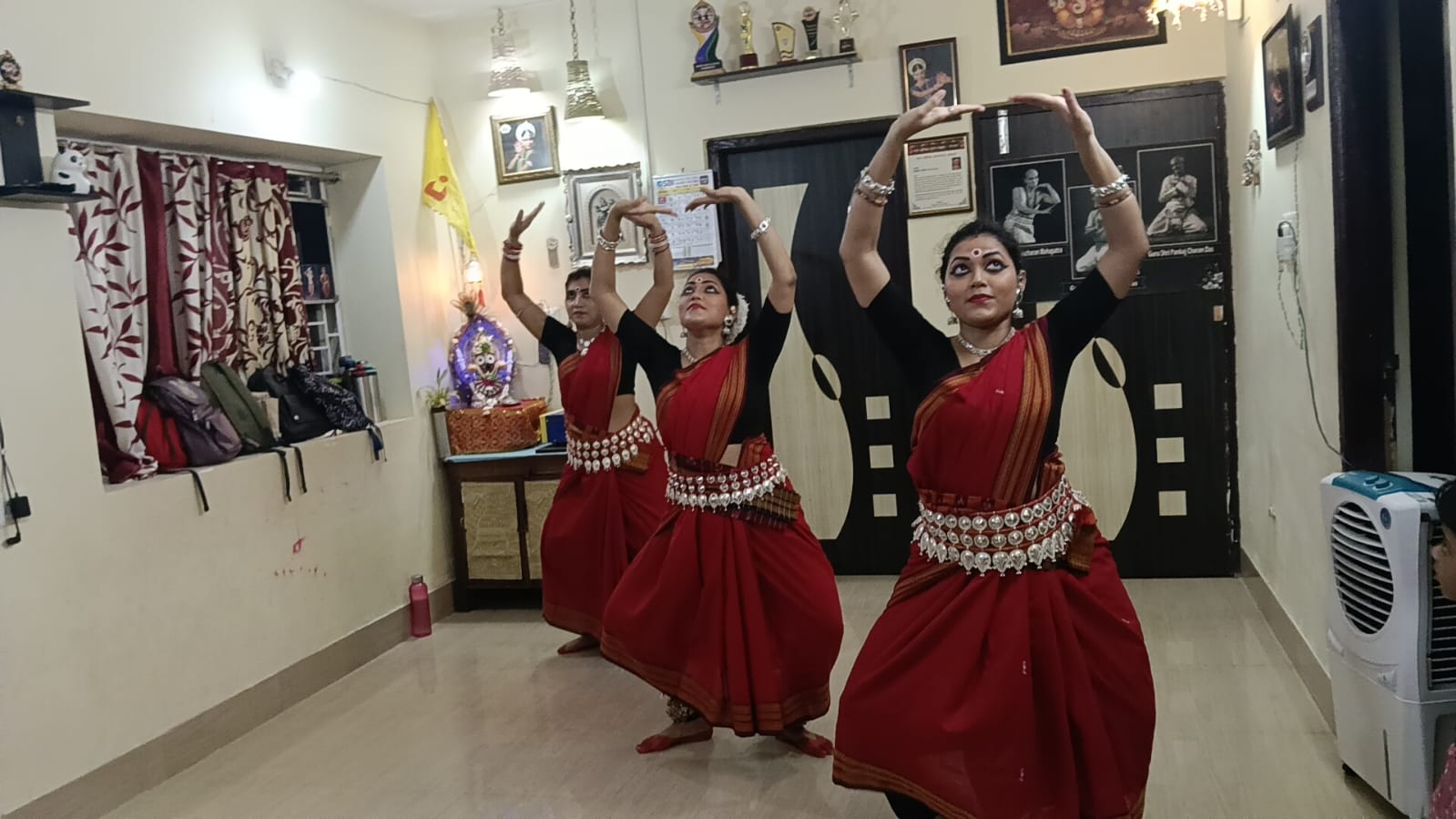 Summer class dancers with arms raised in a synchronised Odissi stance