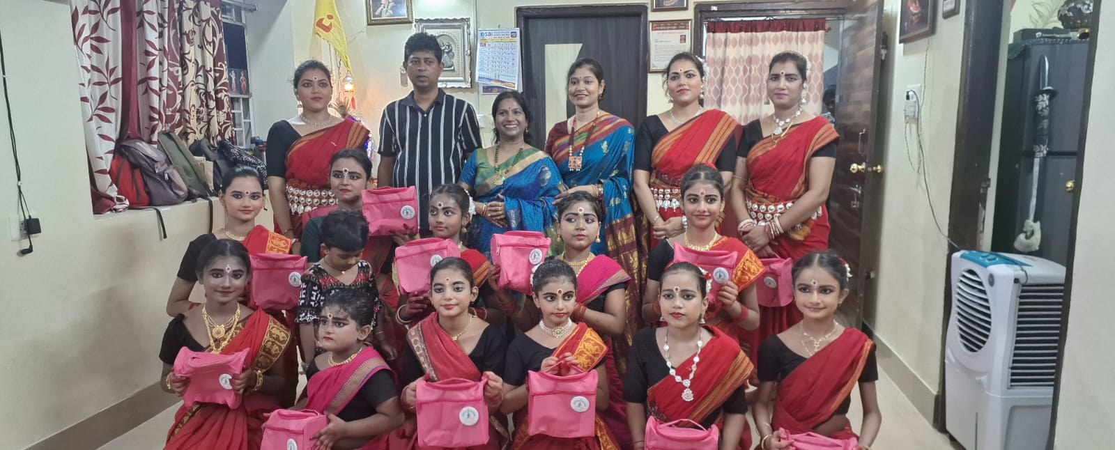 Summer class students with their guru and families holding Nrutyatrupti kit bags