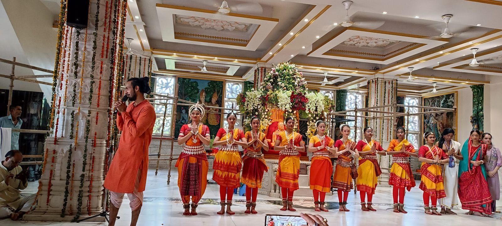 Group of Odissi students performing at a temple hall before the guru murti