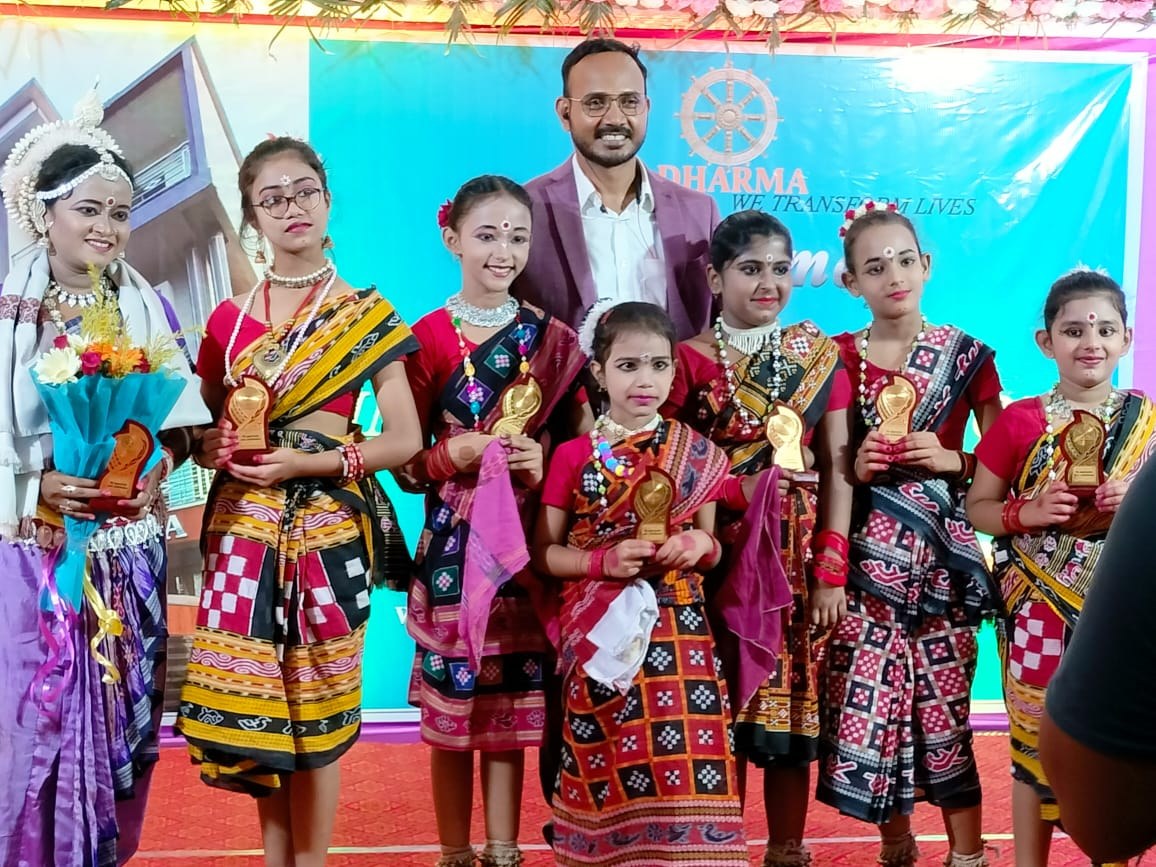 Students holding trophies with a dignitary at an award ceremony