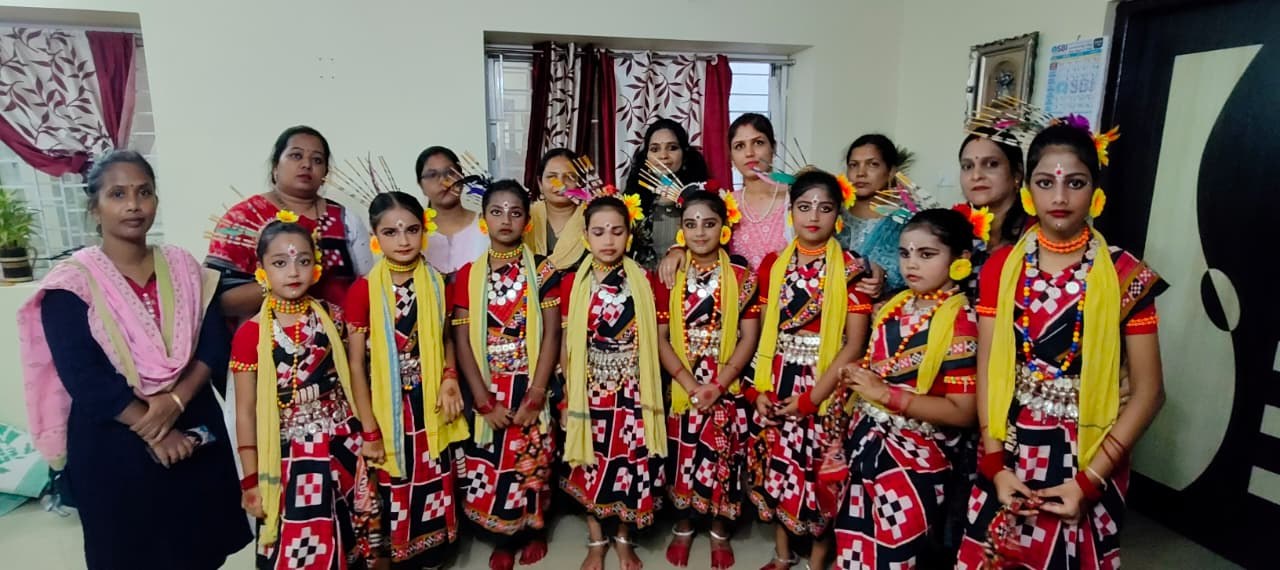 Group of young students and teachers in Sambalpuri folk costume at an indoor gathering